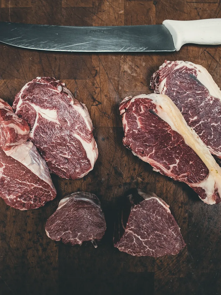 Raw lamb chops and medallions on a wooden block
