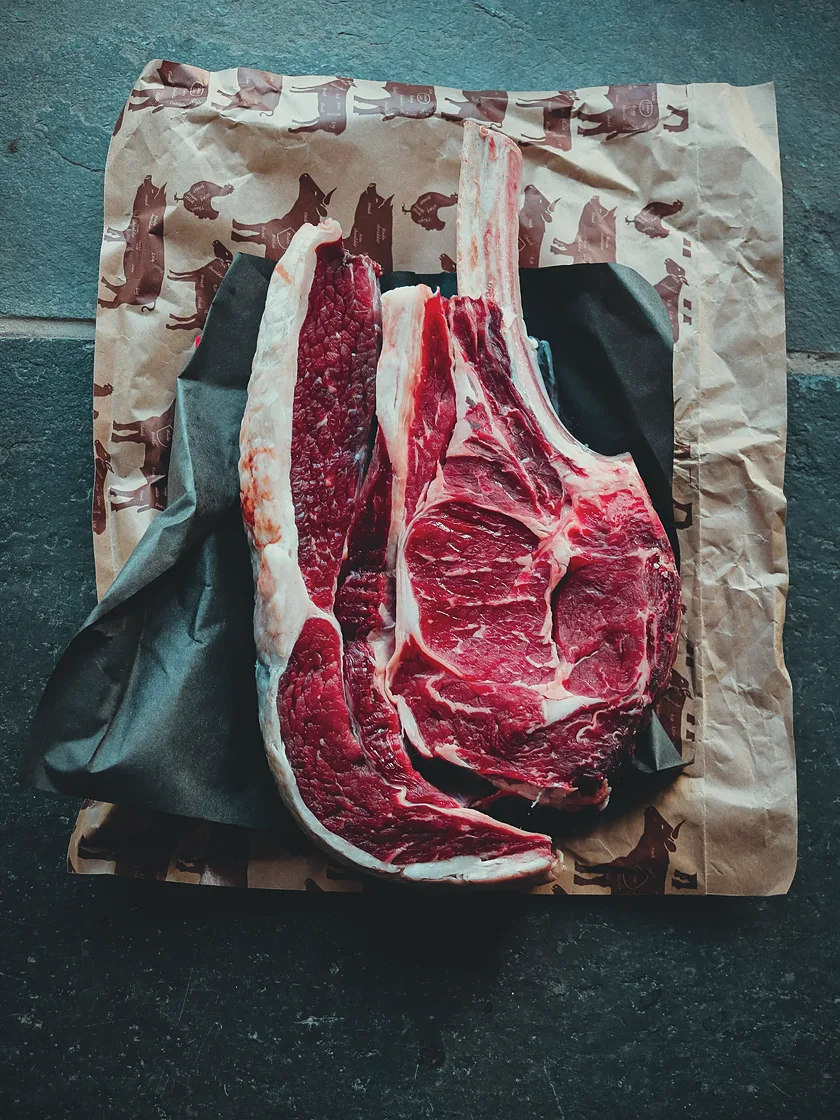 Raw beef tomahawk steaks on butcher paper